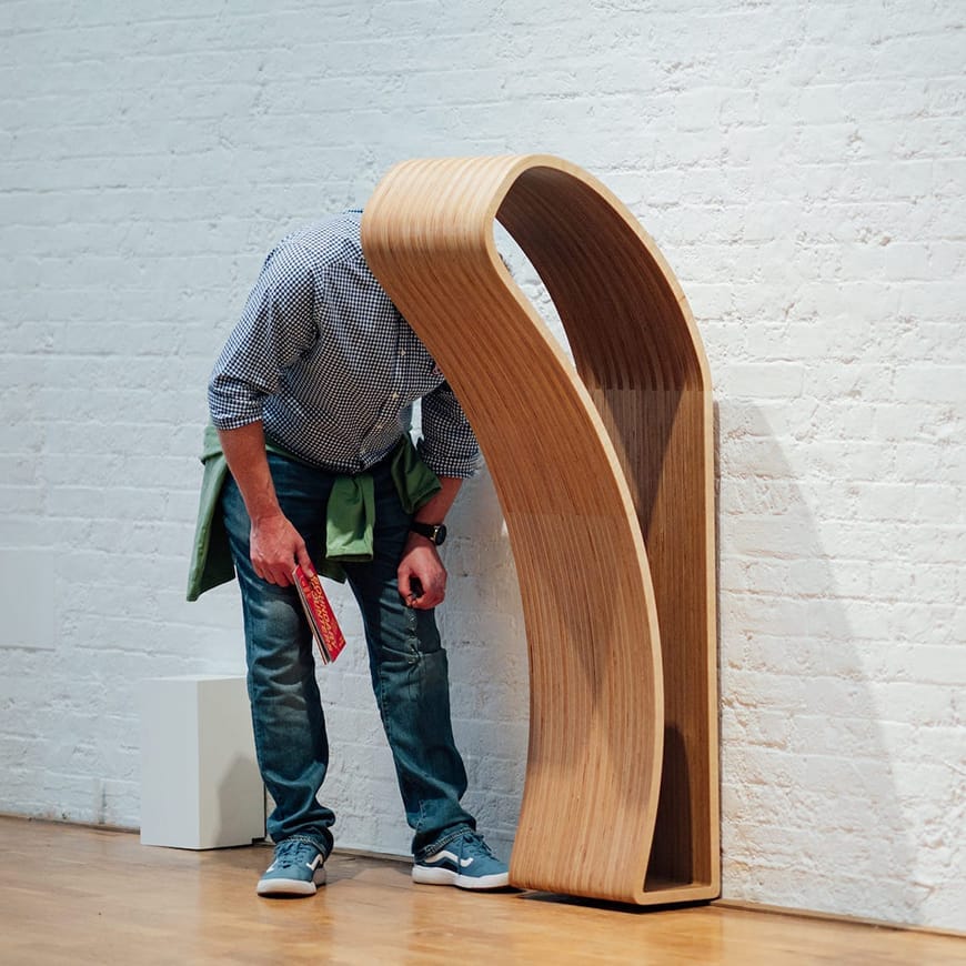 adult man with head inside a wooden sculpture