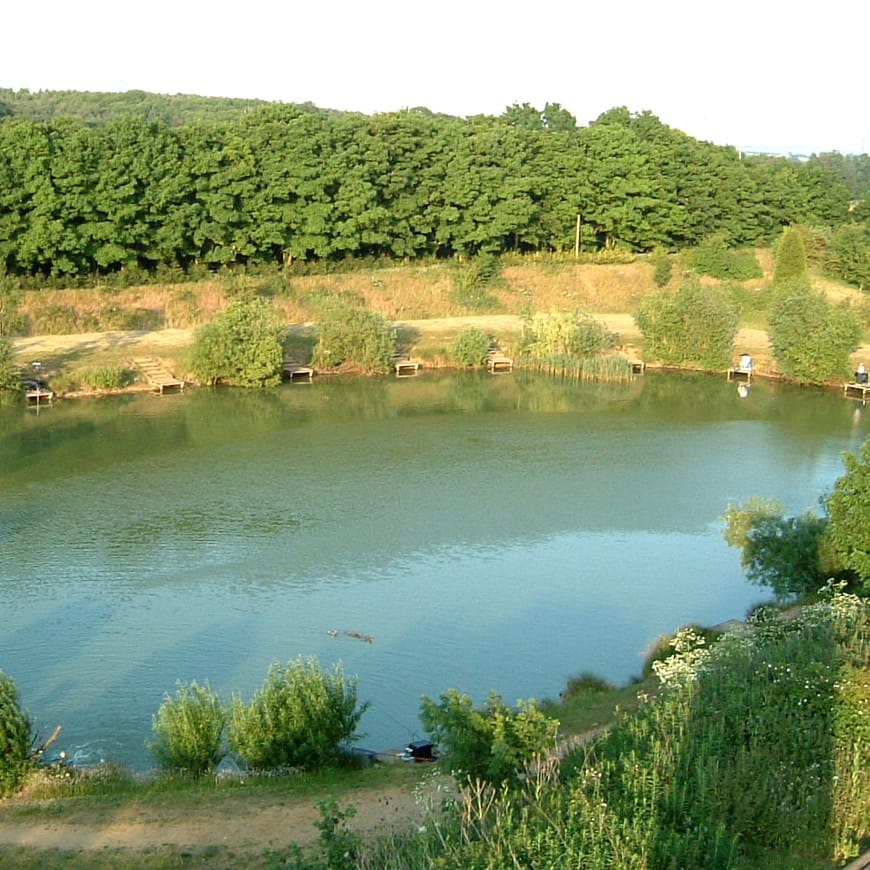 Circular lake with wooden fishing platforms around the edges